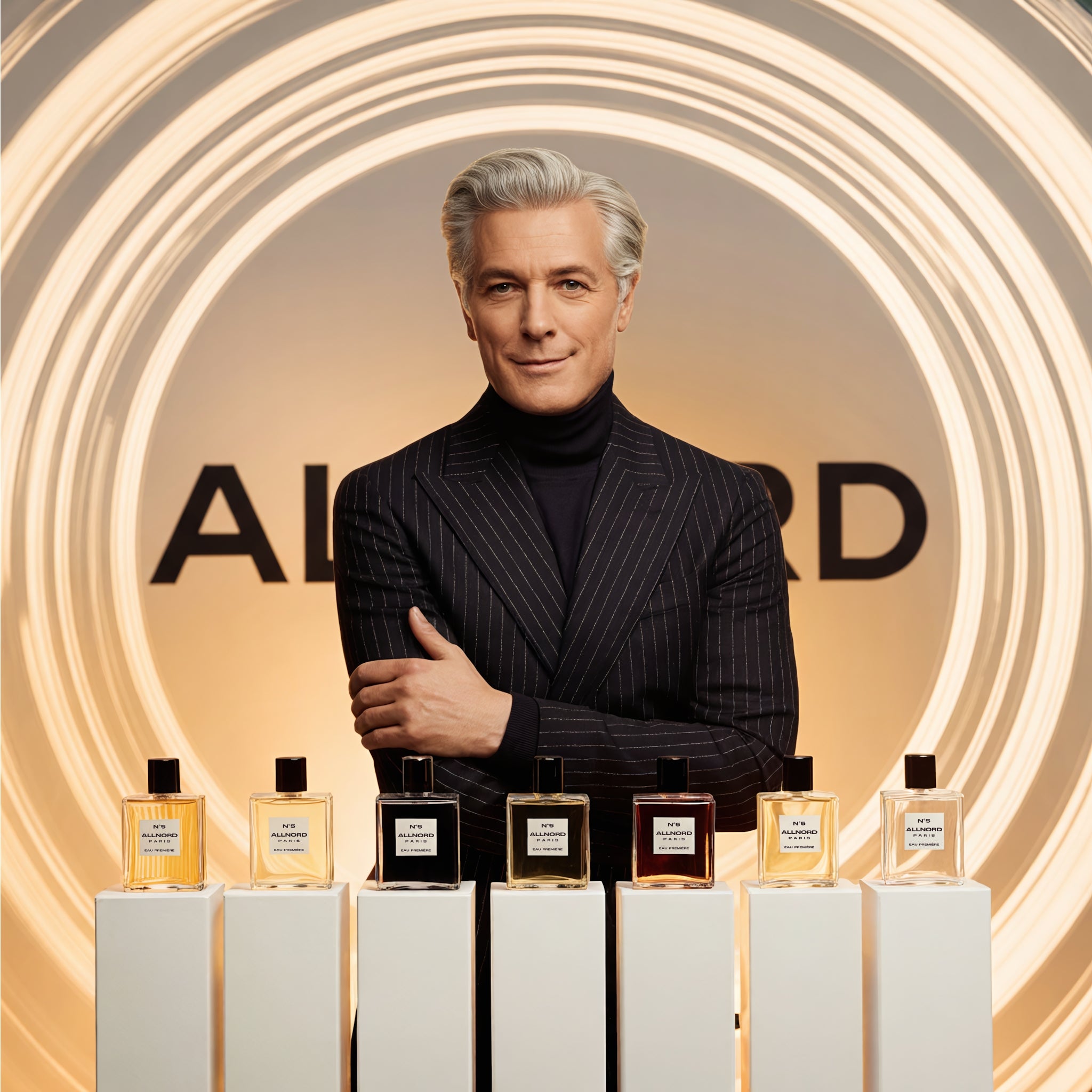 Elegant grey‑haired Allnord founder in a dark pinstripe suit stands behind six Allnord perfume bottles displayed on white plinths, framed by glowing golden light rings and a soft beige backdrop with the brand logo.​